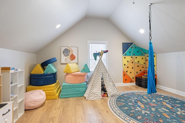 rec room featuring baseboards, lofted ceiling, and wood finished floors