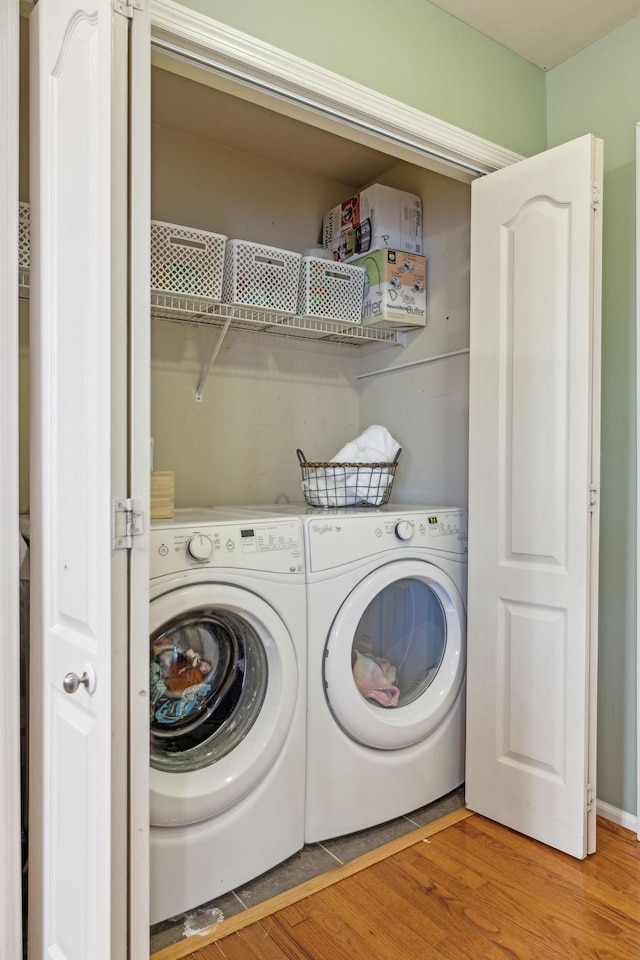 laundry room with laundry area, washer and dryer, and light wood-type flooring