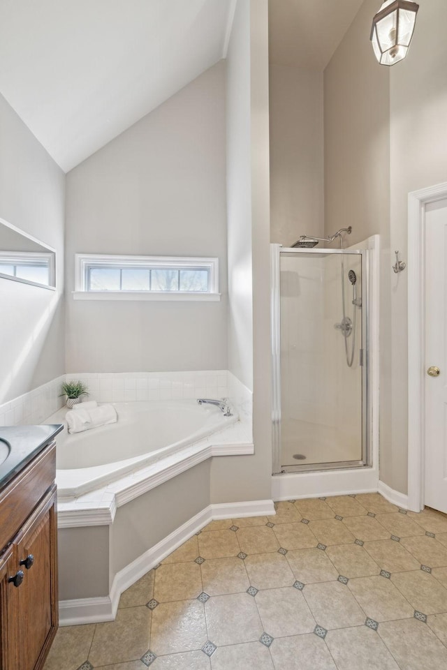 bathroom with vanity, a shower stall, vaulted ceiling, a garden tub, and tile patterned floors