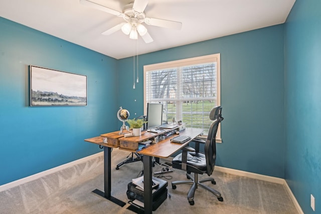 carpeted home office with baseboards and ceiling fan