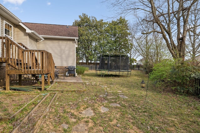 view of yard with a patio area, a trampoline, and fence