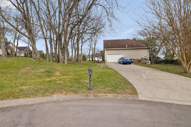 view of yard with concrete driveway and a garage