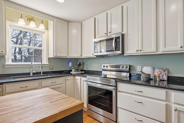 kitchen featuring a sink, stainless steel appliances, and white cabinetry