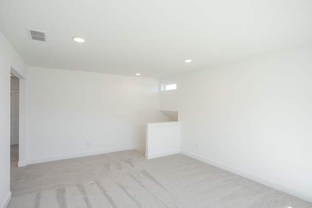 unfurnished room with light colored carpet, recessed lighting, visible vents, and baseboards