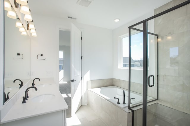 bathroom with a bath, a healthy amount of sunlight, visible vents, and a sink