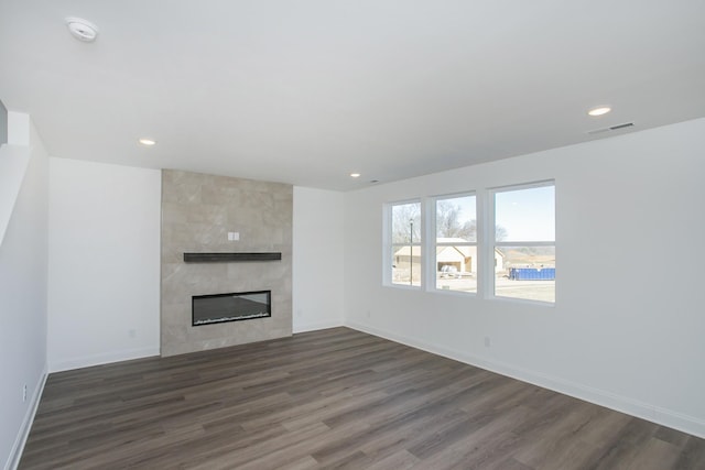 unfurnished living room featuring dark wood-style floors, recessed lighting, a fireplace, and visible vents