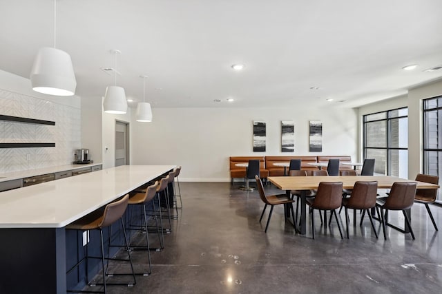 dining room with recessed lighting, baseboards, and finished concrete floors