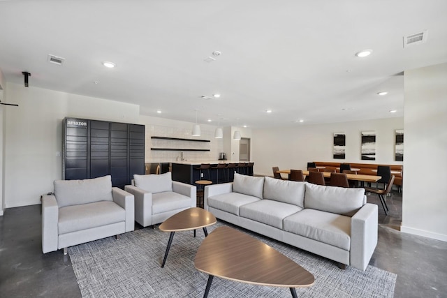 living room featuring recessed lighting, finished concrete flooring, and visible vents