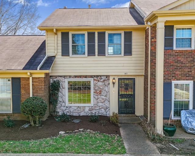 view of front facade featuring brick siding and stone siding