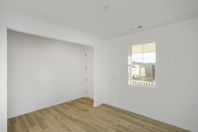 unfurnished room with visible vents, baseboards, and wood finished floors