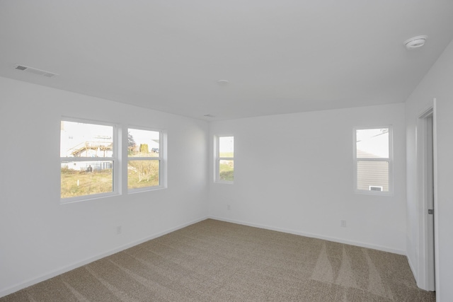 carpeted empty room featuring visible vents and baseboards