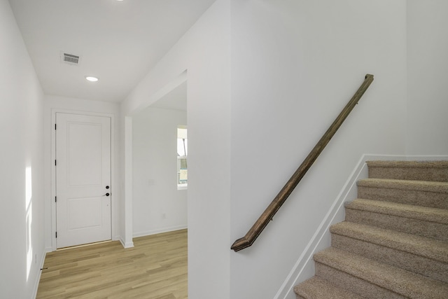 stairs featuring recessed lighting, visible vents, baseboards, and wood finished floors