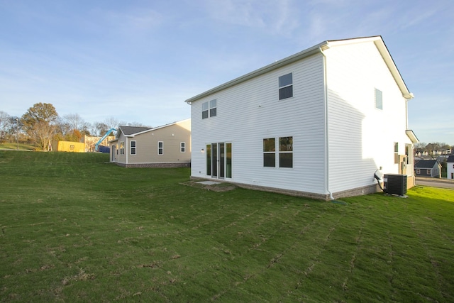 rear view of house featuring a yard and central AC