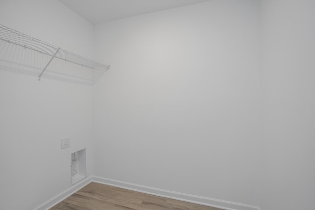 washroom with baseboards, hookup for an electric dryer, light wood-style flooring, and laundry area