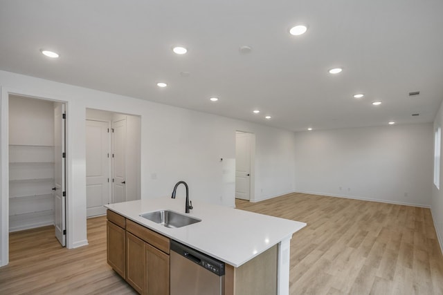 kitchen featuring a sink, recessed lighting, light wood-style flooring, stainless steel dishwasher, and a kitchen island with sink