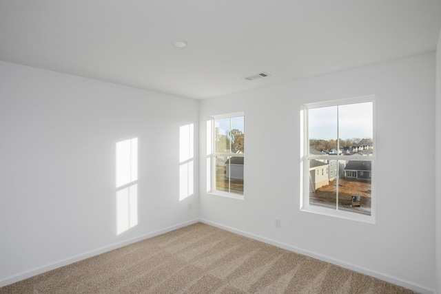 empty room featuring visible vents, baseboards, and carpet floors