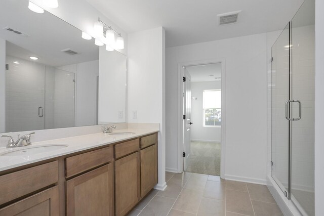 bathroom featuring tile patterned flooring, visible vents, a shower stall, and a sink