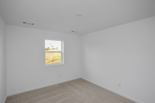 carpeted empty room featuring visible vents and baseboards