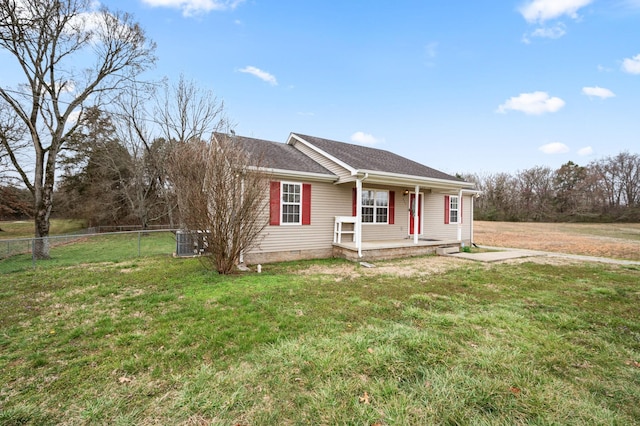 view of front of home with a shingled roof, fence, a porch, a front yard, and central AC unit