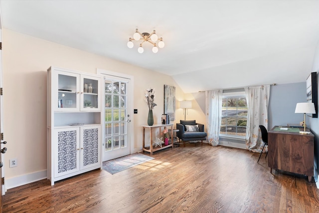 living area featuring baseboards, wood finished floors, and vaulted ceiling