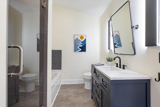 bathroom with baseboards, toilet, a tub to relax in, and vanity