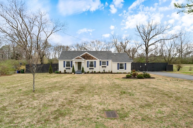 ranch-style house with driveway, a front lawn, and fence