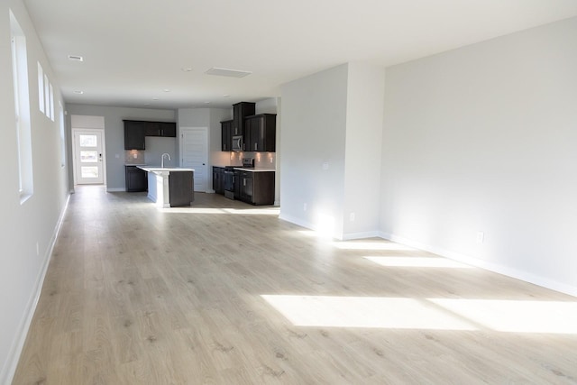 unfurnished living room with light wood finished floors and baseboards