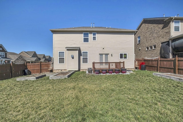 rear view of house featuring a garden, a yard, and fence private yard