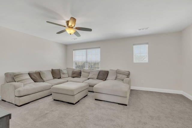 living area featuring carpet, baseboards, visible vents, and a ceiling fan