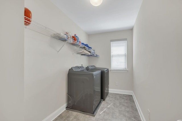 laundry room featuring washer and dryer, laundry area, light floors, and baseboards