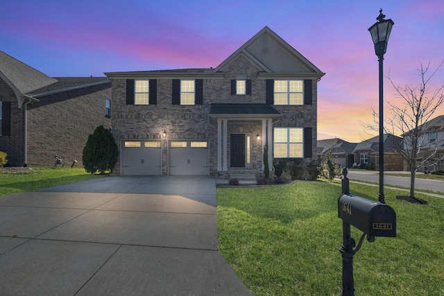 traditional-style home with an attached garage, brick siding, a yard, and driveway