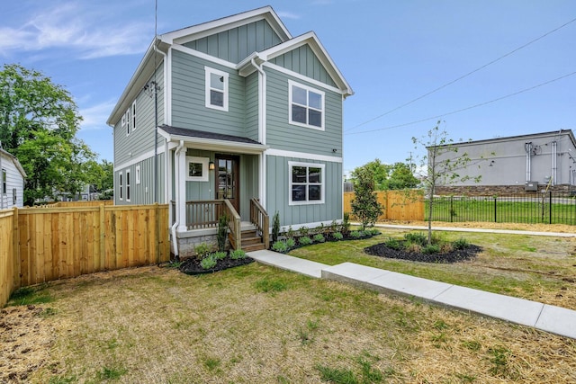 view of front of property featuring a front lawn, fence, and board and batten siding