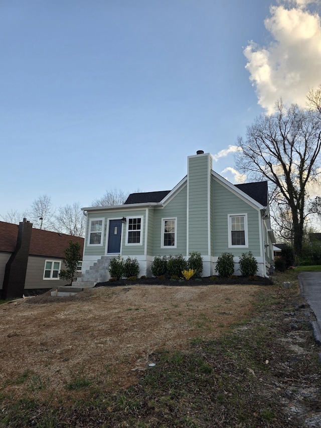 view of front of property with entry steps and a chimney
