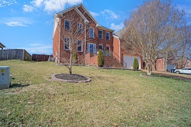 view of front facade with brick siding, a front lawn, and fence