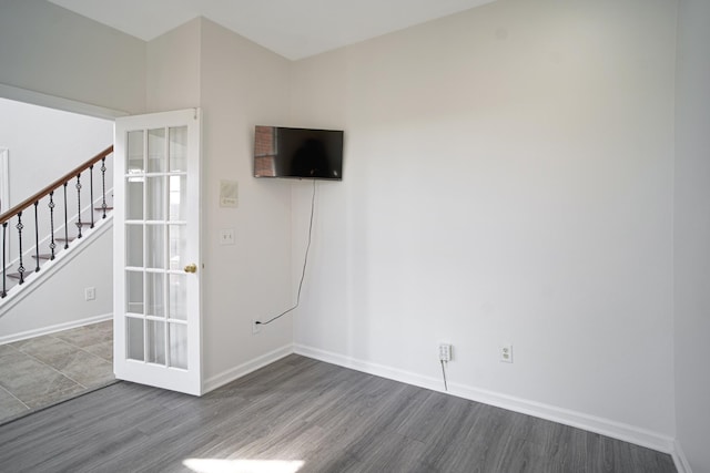 spare room featuring stairway, baseboards, and wood finished floors