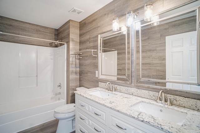 full bath with double vanity, toilet, visible vents, and a sink