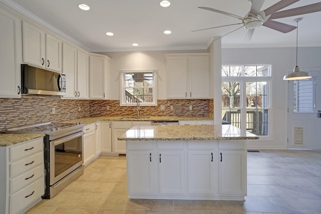 kitchen with light stone countertops, ceiling fan, a sink, stainless steel appliances, and tasteful backsplash