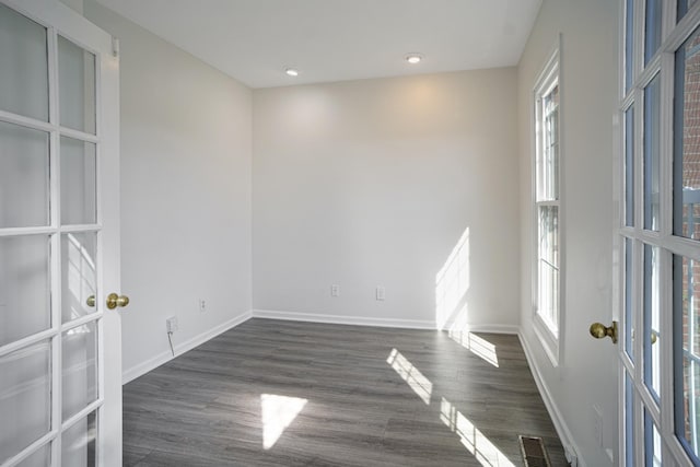 empty room with visible vents, baseboards, dark wood finished floors, and french doors