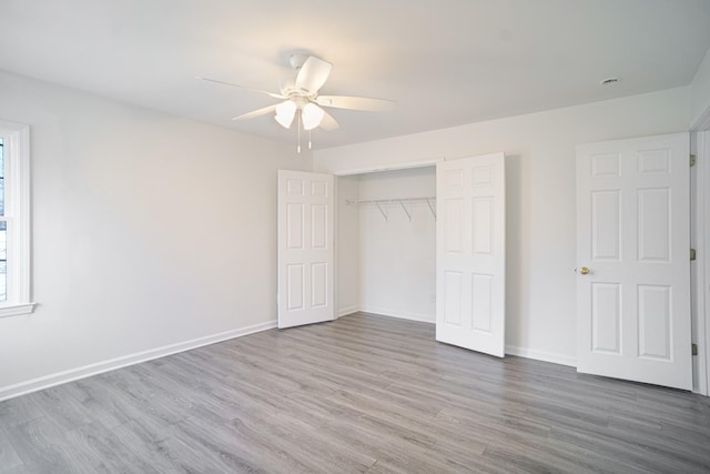 unfurnished bedroom with wood finished floors, baseboards, a closet, and ceiling fan