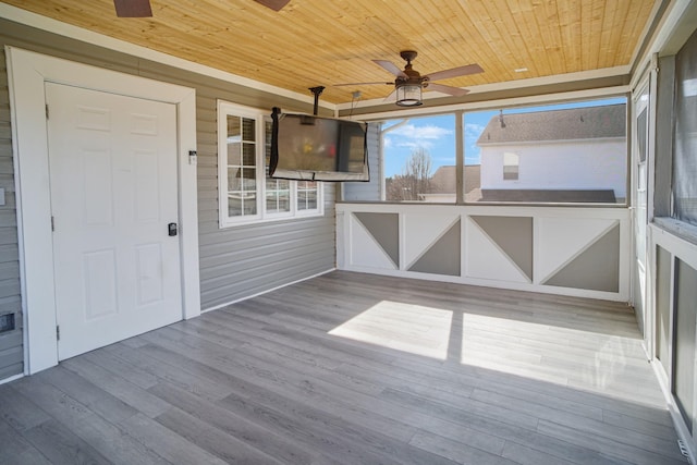 unfurnished sunroom featuring wooden ceiling and ceiling fan