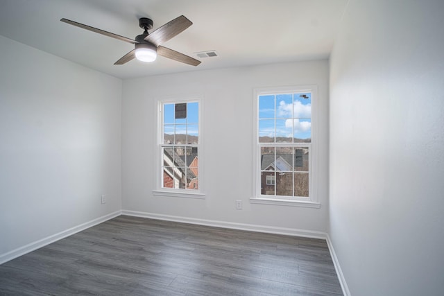 unfurnished room with dark wood-type flooring, plenty of natural light, and baseboards