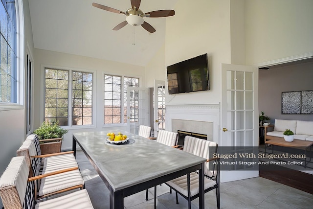 sunroom featuring a glass covered fireplace, radiator heating unit, ceiling fan, and vaulted ceiling