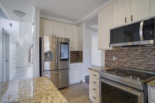 kitchen with light stone counters, tasteful backsplash, appliances with stainless steel finishes, and crown molding