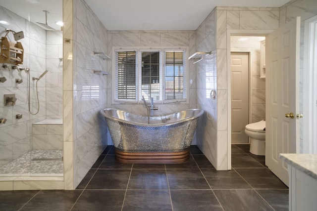 bathroom featuring a soaking tub, tile walls, a shower stall, and toilet