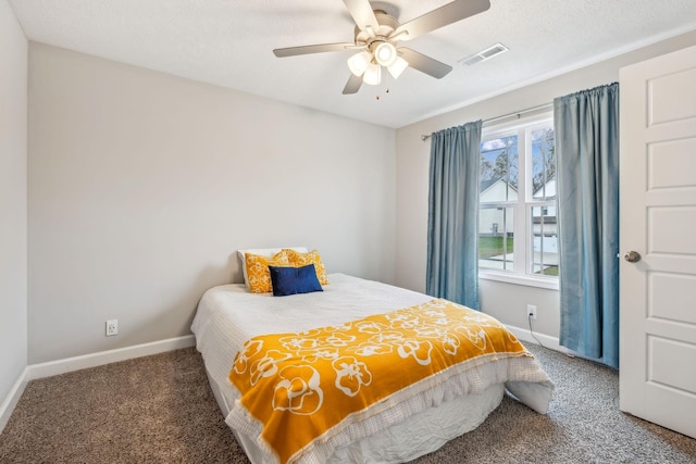 carpeted bedroom with a ceiling fan, baseboards, visible vents, and a textured ceiling