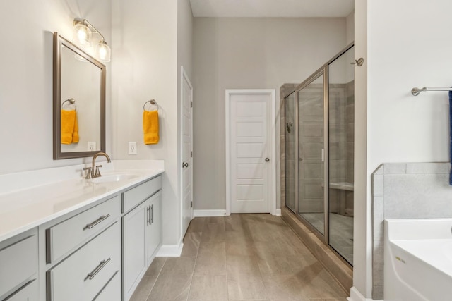 full bathroom with baseboards, a stall shower, vanity, and a bath