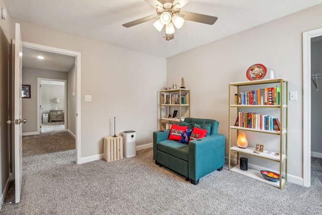 living area with baseboards, a ceiling fan, and carpet floors