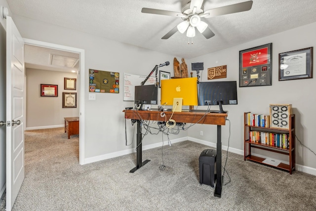 carpeted office space with baseboards, attic access, a textured ceiling, and a ceiling fan