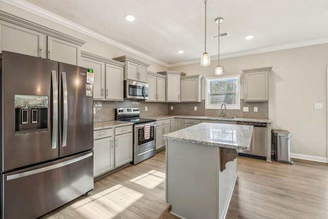 kitchen featuring visible vents, backsplash, light wood-type flooring, stainless steel appliances, and a sink