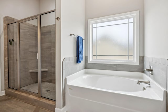 bathroom featuring a bath and a shower stall